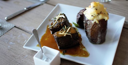Chef Scott Ehrlich's Filet Mignon on a White Plate with Accompaniments at The Dunes