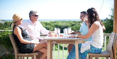 People Enjoying Drinks on the Outdoor Deck at The Dunes