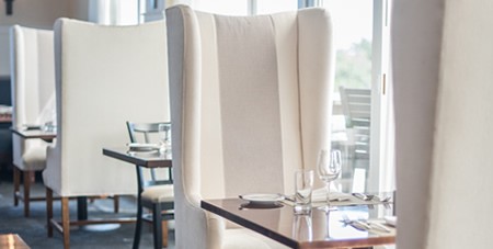 View of the Indoor Dining Room at The Dunes with Large, White Chairs