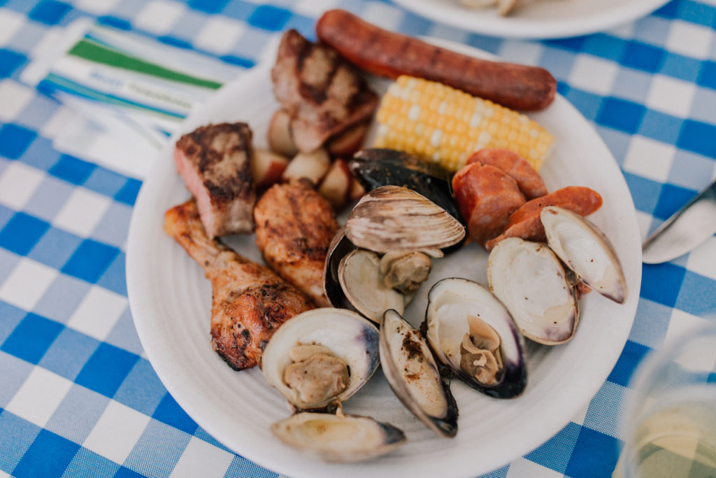 A plate of clams, chicken, sausage and corn on the cob