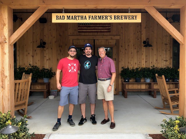 3 men stand in front of Bad Martha Farmer's Brewery