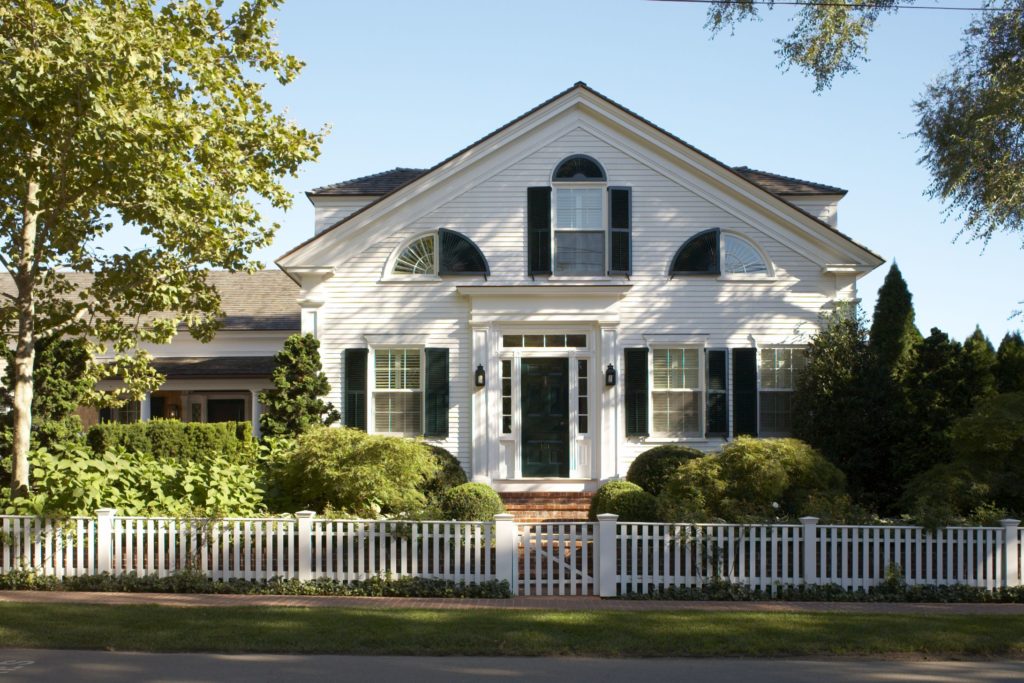 A white house with a white fence in front of it